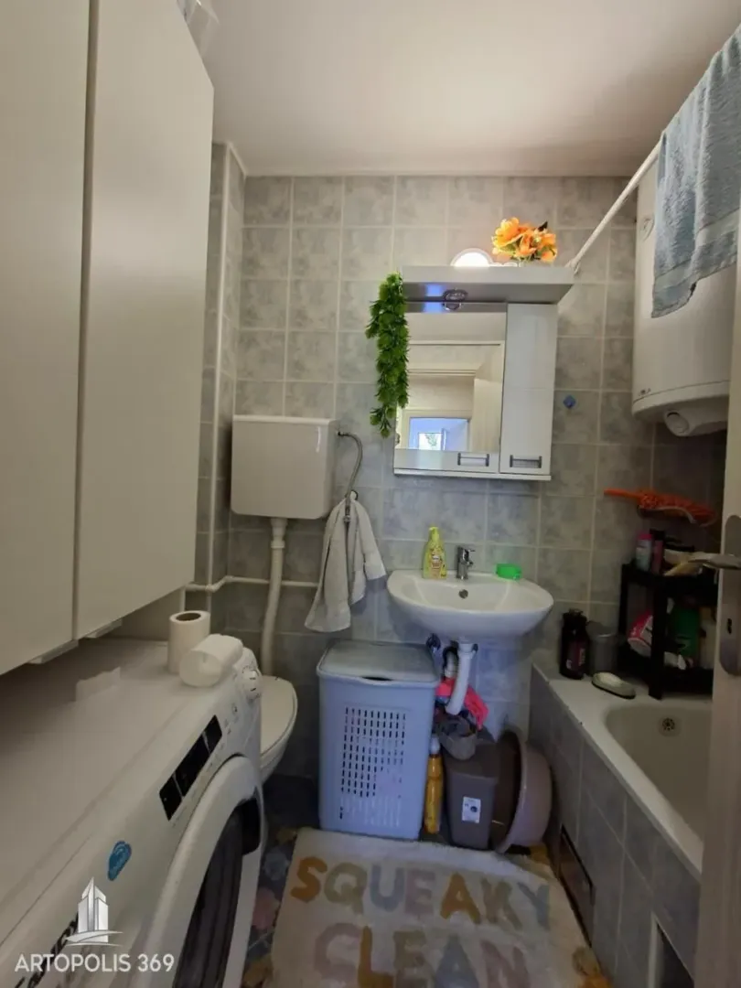 Manje kupatilo sa kadom, umivaonikom, toaletom i veš mašinom.