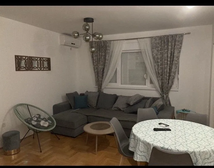 Living room with a sofa set, dining table and air conditioning.