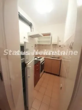 Pogled iz hodnika na manju kuhinju sa osnovnim elementima i belom tehnikom. - image 5
