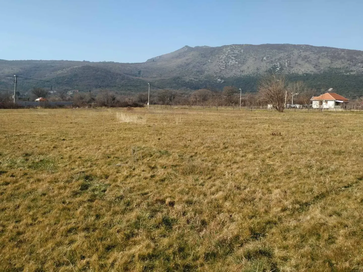 Pogled na ravno zemljište i brda u pozadini.