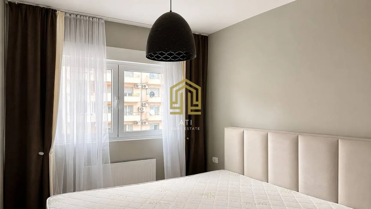 Bedroom with a large window and a bed.