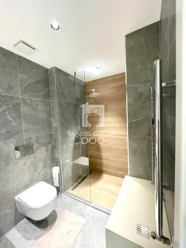 Modernly equipped bathroom with a walk-in shower and a wall-mounted toilet. - image 10