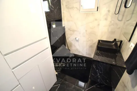 Modern bathroom with a black washbasin and marble tiles. - image 13