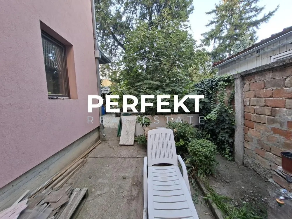 Pogled na dvorište i bočni deo kuće sa ležaljkom.