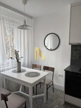 Manja trpezarija i kuhinja sa belim stolom i stolicama. - image 13