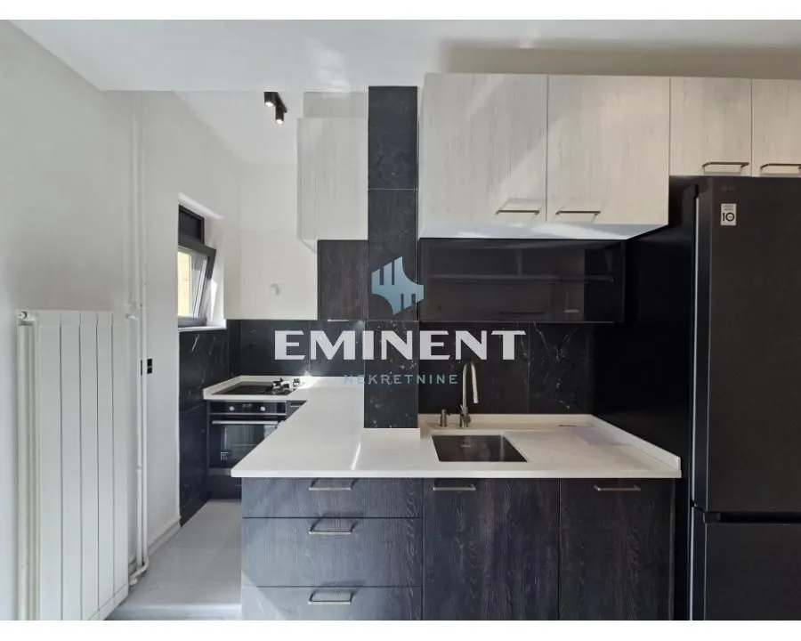 Modern kitchen with white upper cabinets and dark lower cabinets.