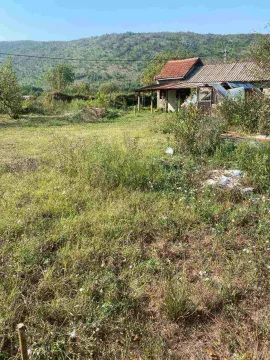 Pogled na stariju kuću sa dvorištem i brdom u pozadini. - image 2