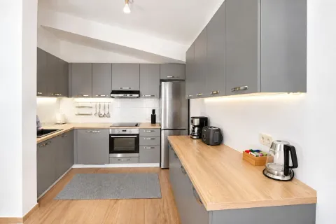 Modern kitchen with grey cabinets and a wooden countertop. - image 5