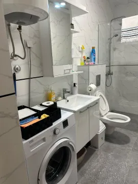 Modernly equipped bathroom with a washing machine and shower cabin. - image 8