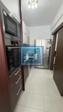 Long kitchen equipped with built-in cabinetry and stainless steel appliances. - image 7
