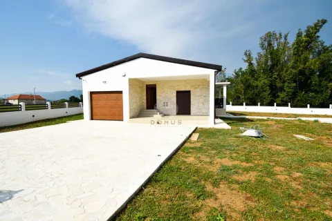 View of the front facade of a single-story house with a yard and garage. - image 5