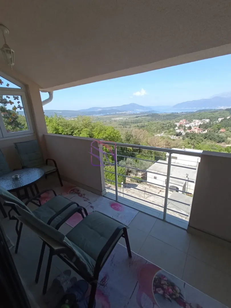 Natkriveni balkon sa garniturom za sjedenje i pogledom na prirodu.