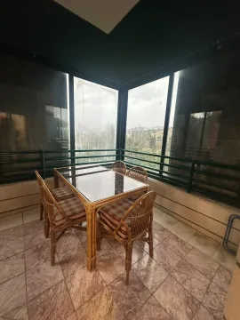 Covered terrace with a dining table and wicker chairs. - image 13