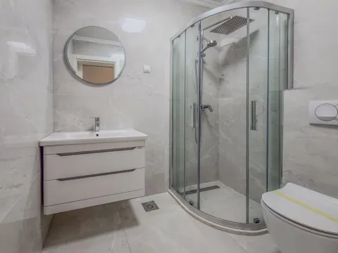 Moderno opremljeno kupatilo sa tuš kabinom, umivaonikom i WC šoljom. - image 6