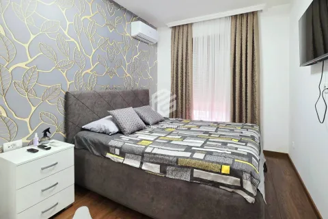Furnished bedroom with a double bed, nightstand, and patterned wallpaper on the wall. - image 11