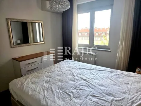 Nameštena spavaća soba sa velikim bračnim krevetom, komodom i ogledalom. - image 5