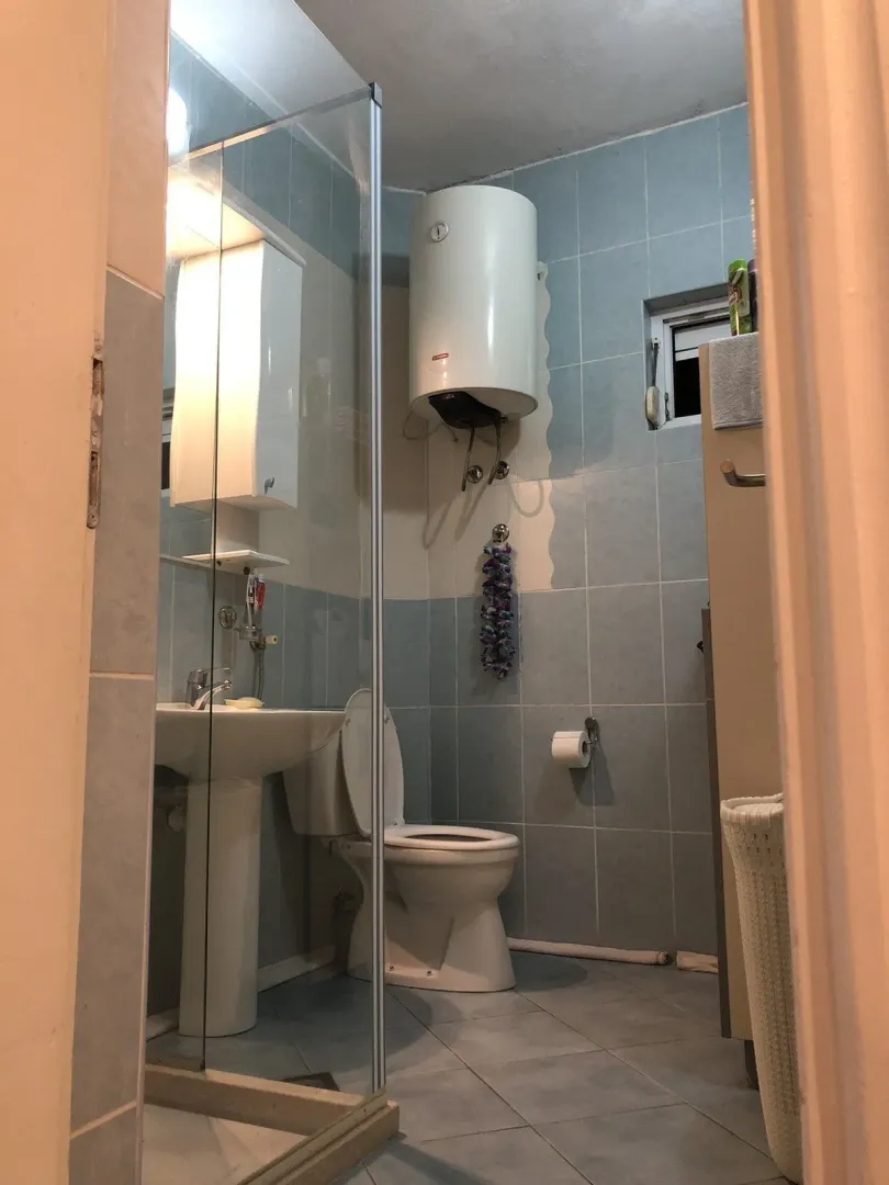 A simple bathroom with a toilet, sink, and water heater.