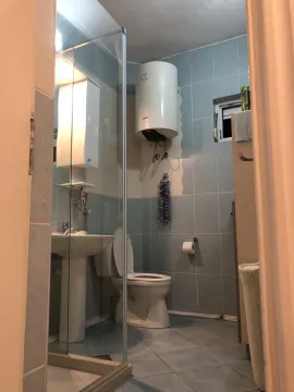 A simple bathroom with a toilet, sink, and water heater. - image 21