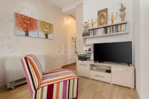 Dnevni boravak sa foteljom, TV-om, policom za knjige i slikama na zidu. - image 2