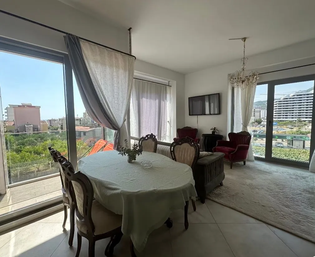 Spacious living room with a dining area and large glass surfaces.