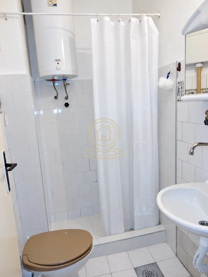 Manje kupatilo sa tuš kabinom, WC šoljom i umivaonikom.