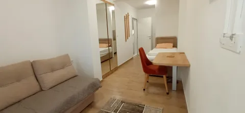 Small living room with a sofa, a bed, and a dining table. - image 7