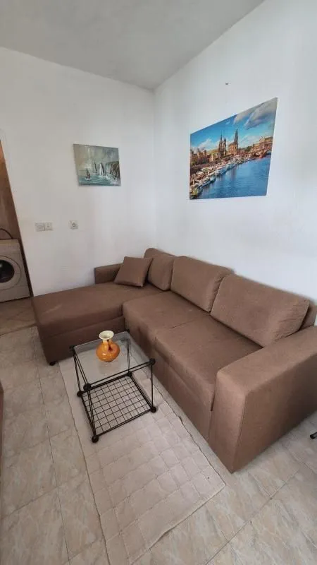 Living room with a brown sectional sofa and a glass coffee table.