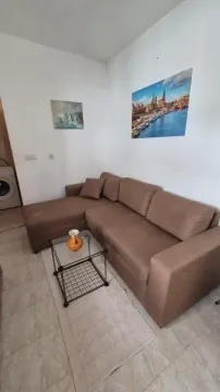 Living room with a brown sectional sofa and a glass coffee table. - image 10