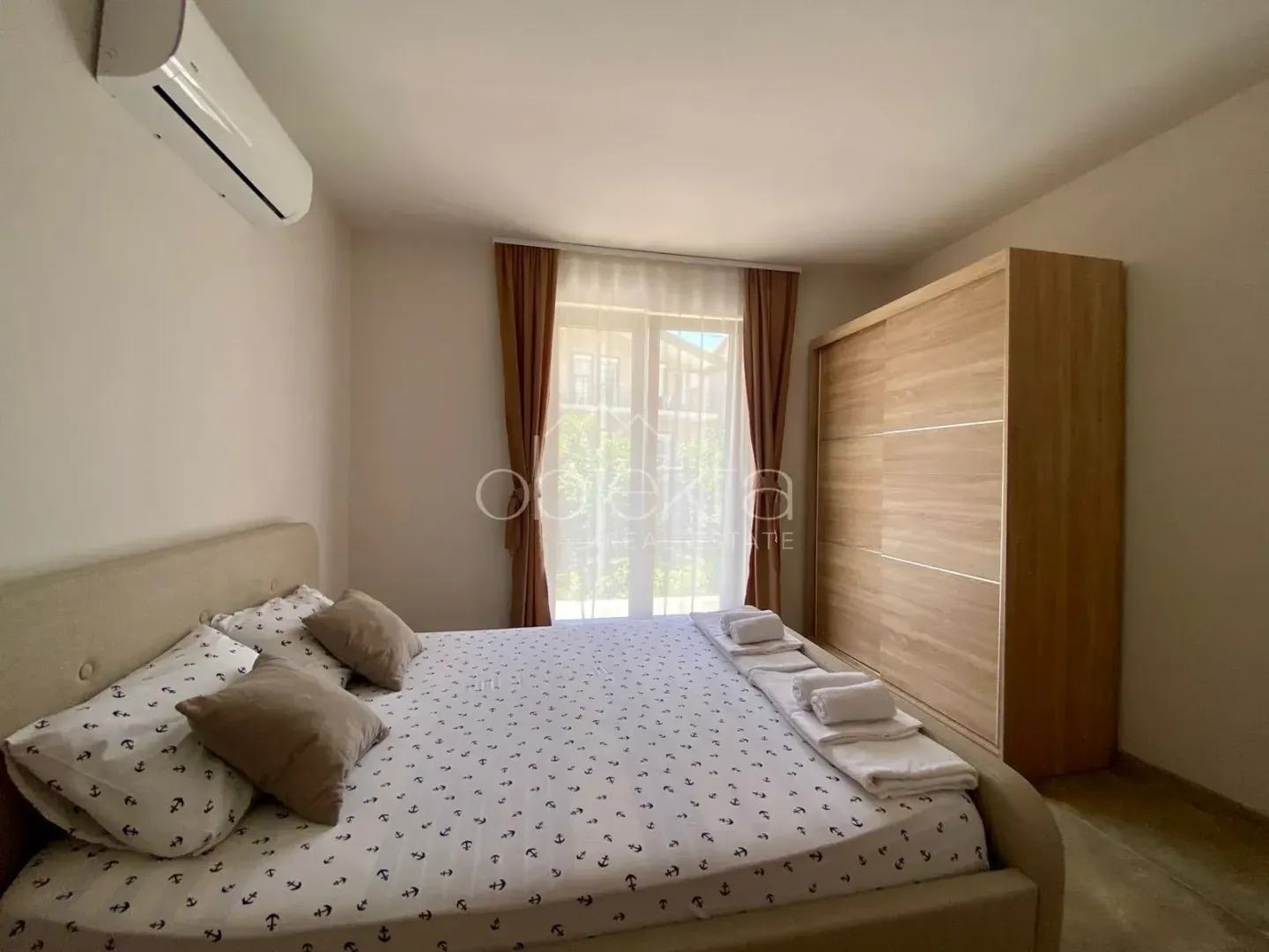 Furnished bedroom with a double bed, wardrobe, and air conditioning.