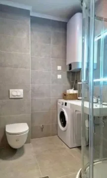 Savremeno opremljeno kupatilo sa tuš kabinom i veš mašinom. - image 4