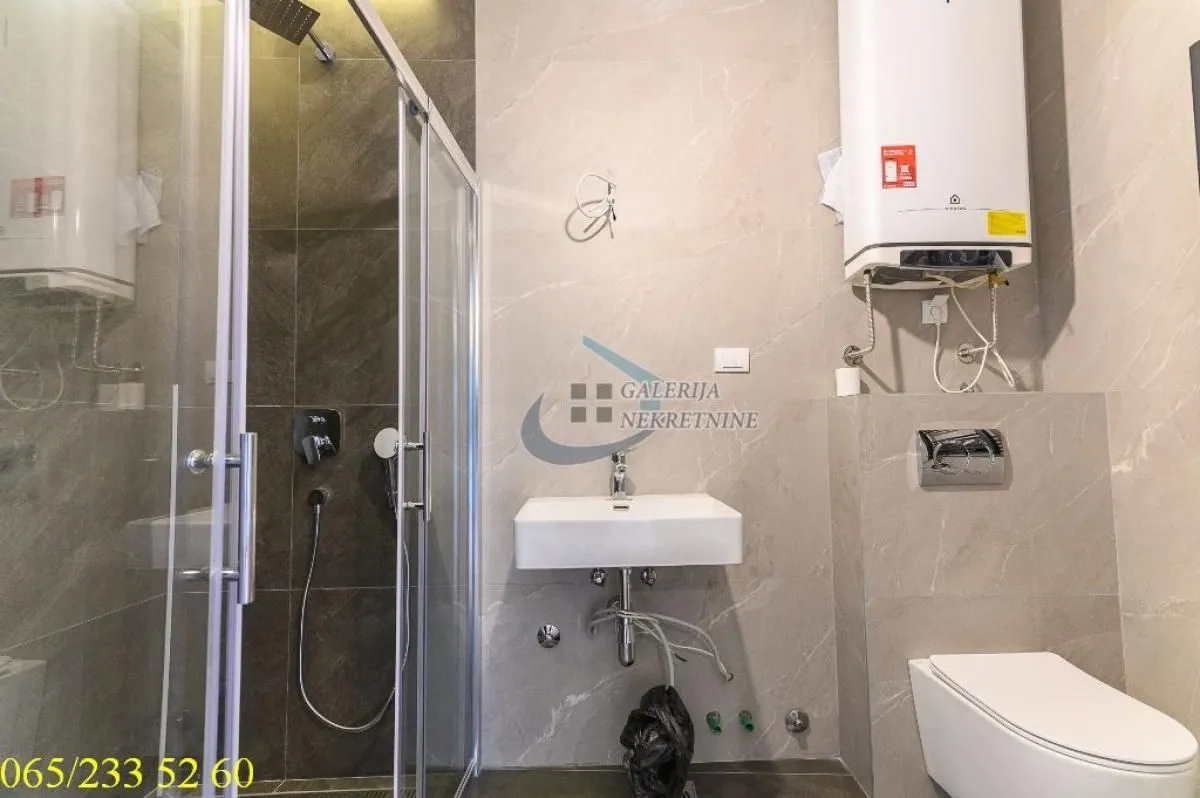 Savremeno opremljeno kupatilo sa tuš kabinom, umivaonikom i wc šoljom.