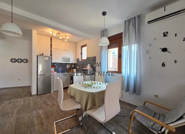 Living room with dining area and kitchen in light tones.