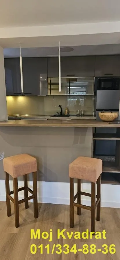 Moderna kuhinja sa šankom i barskim stolicama.