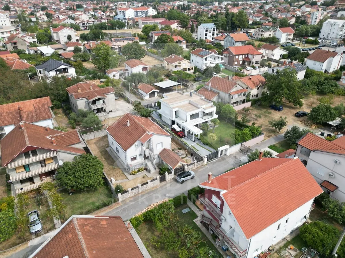 Aerial view of a suburban neighborhood with family houses and greenery.