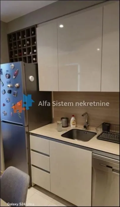 Manja kuhinja sa frižiderom, sudoperom i ugradnim elementima.