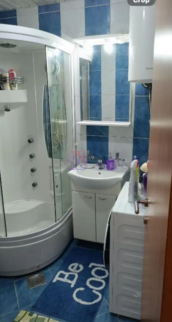 Kupatilo sa tuš kabinom, umivaonikom i veš mašinom.