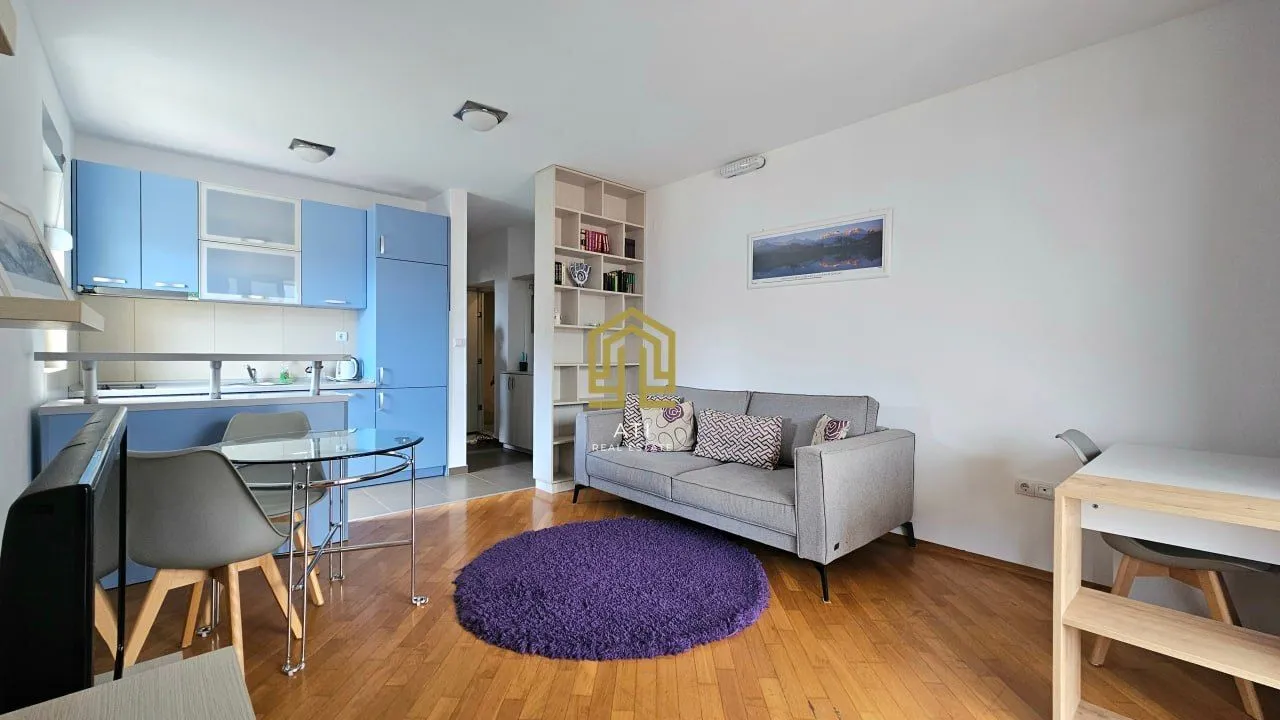 Living room connected to the kitchen and dining area in bright tones.