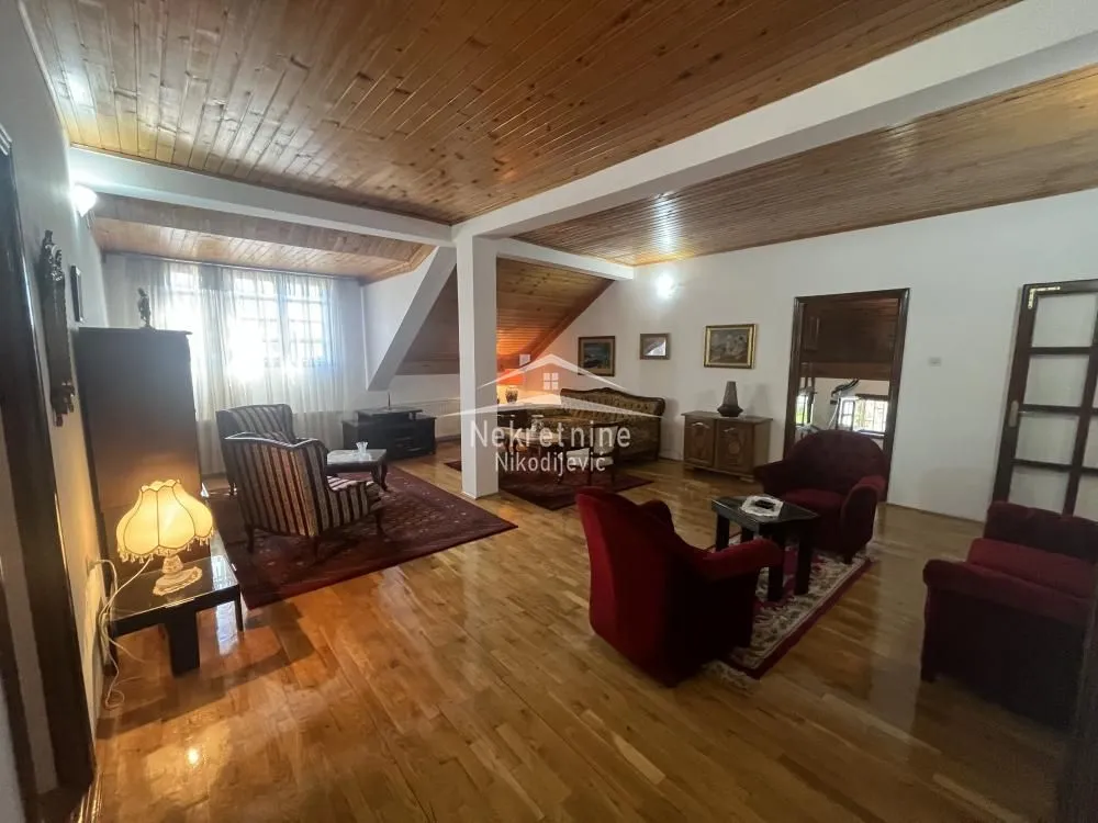 Spacious living room with wooden flooring and ceiling.