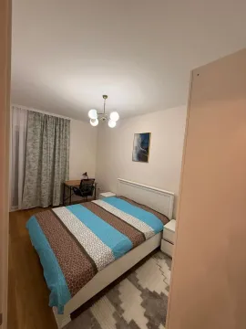 Svijetla spavaća soba sa bračnim krevetom, radnim stolom i lusterom. - image 11