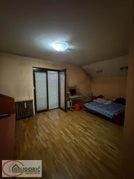 Bedroom with a bed, desk, and balcony access. - image 10