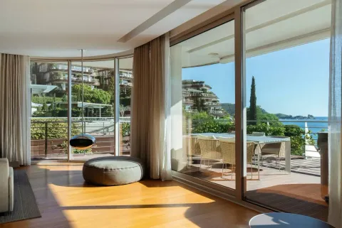 Living room with large glass surfaces and a view of the terrace and the sea. - image 4