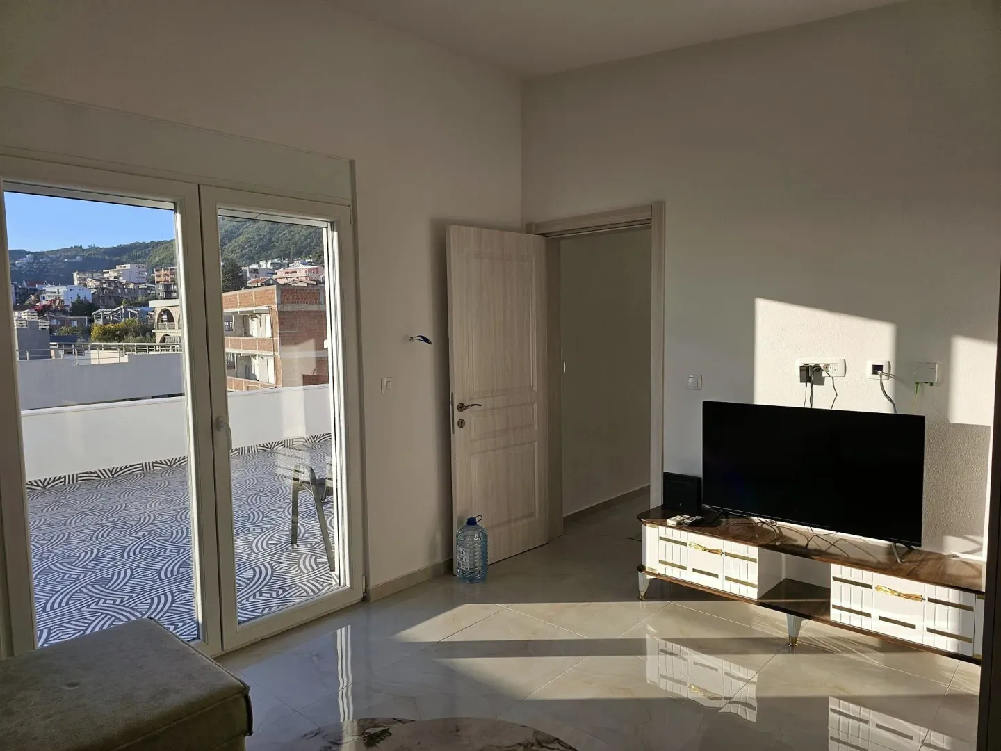 Living room with a TV and access to a spacious terrace.