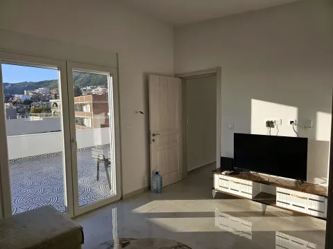 Living room with a TV and access to a spacious terrace. - image 2