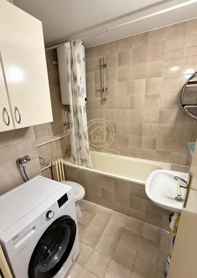 Bathroom equipped with a bathtub, sink, toilet, and washing machine.
