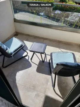 Manja opremljena terasa sa garniturom za sjedenje i staklenom ogradom. - image 3