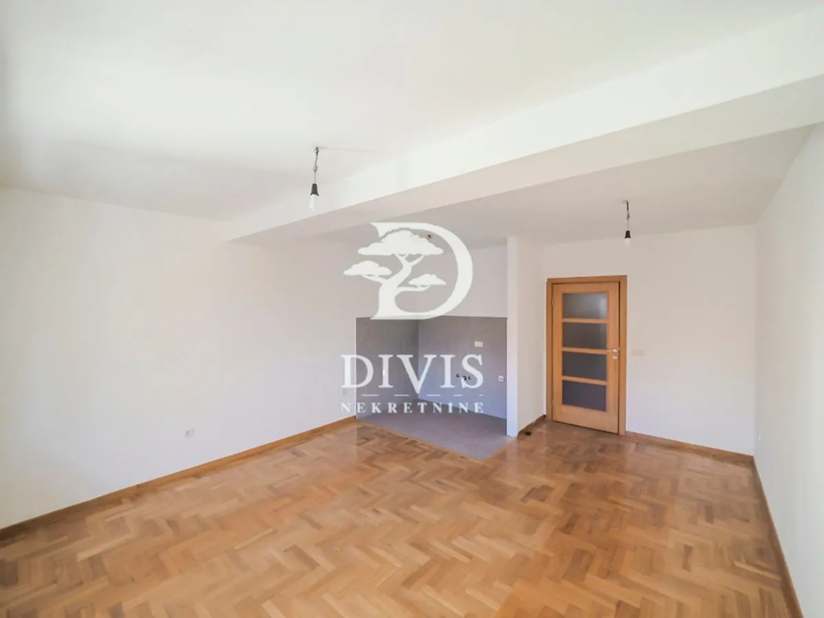 Empty room with parquet flooring and wooden doors.