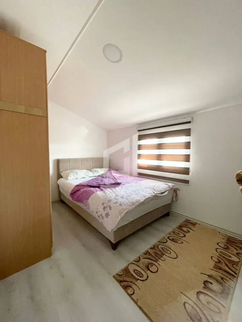 Bedroom with a double bed, wardrobe, and window.