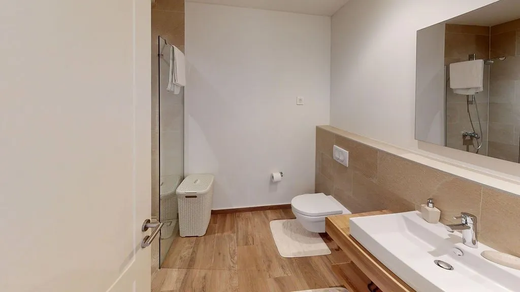 Moderno kupatilo sa tuš kabinom, lavaboom i toaletom.