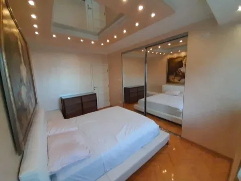 Bedroom with a double bed, large mirror, and built-in wardrobe. - image 7