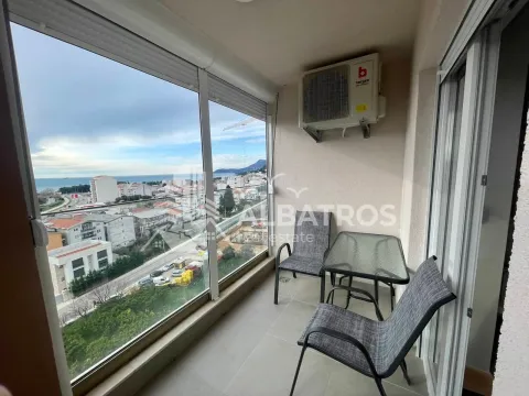 Enclosed balcony with seating furniture and a view of the city and the sea. - image 10